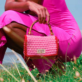 Stylish AIRMAIL Mini Crochet Handbag In Pink, perfect for casual outings, featuring a chic bamboo handle.